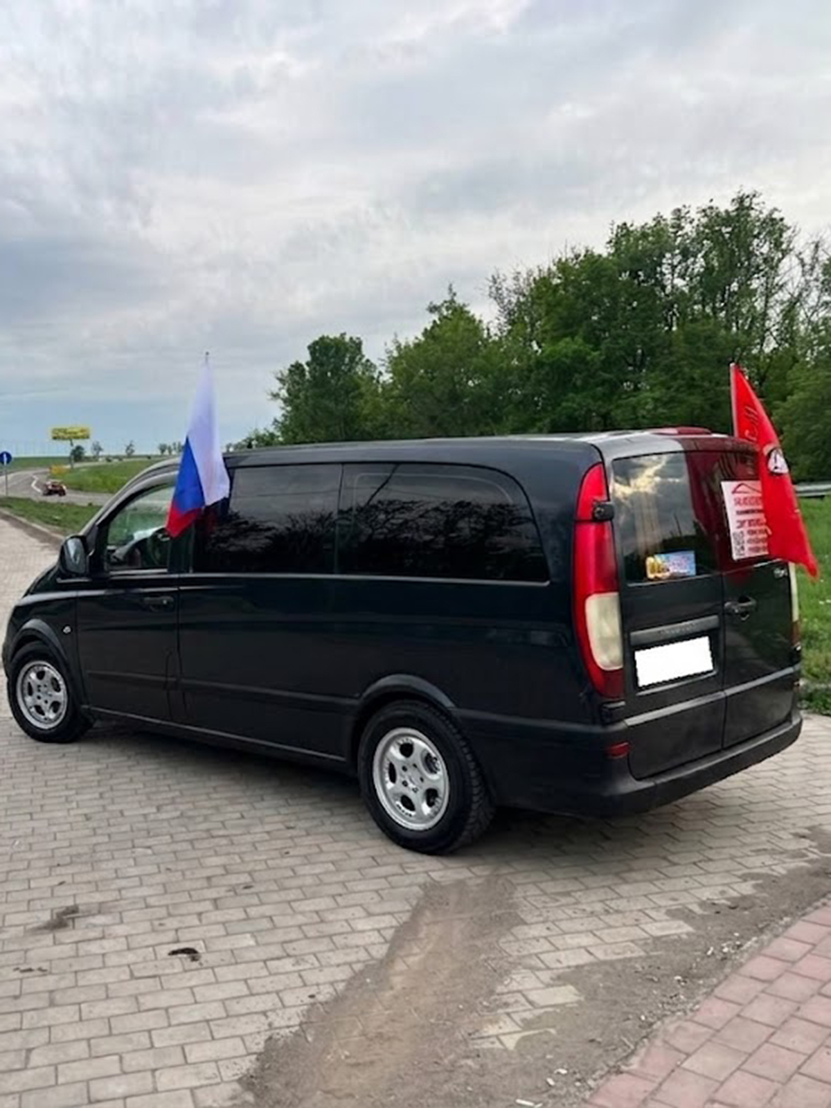 Черный пассажирский микроавтобус с флагом